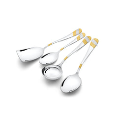 Four stainless steel serving utensils with decorative gold and silver handles arranged diagonally, including spatula, spoons, and ladle on clean white background.