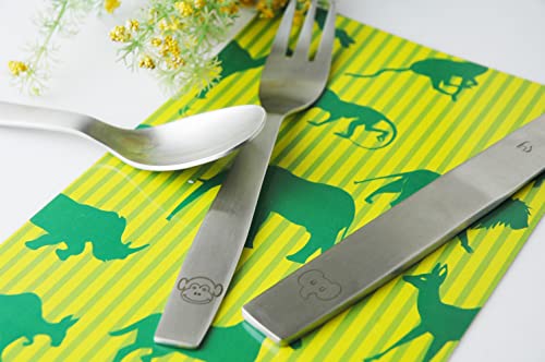 Spoon, fork, and knife featuring monkey and elephant engravings on jungle-printed napkin background.