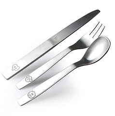Fun animal-engraved spoon, fork, and knife set arranged diagonally on bright white background.