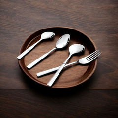Elegant cutlery set displayed in a wooden plate, resting on a dark brown wooden table.