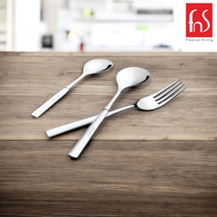 Three polished cutlery pieces arranged on wooden table with blurred kitchen background and brand logo.