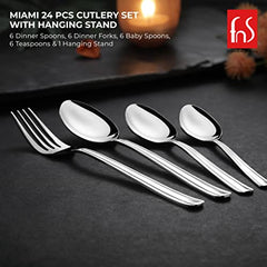 Four polished stainless steel utensils arranged on dark surface showing elegant design and craftsmanship quality