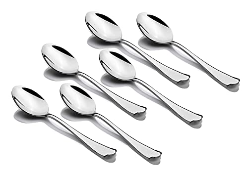 Six polished stainless steel tablespoons arranged diagonally with matching contoured handles on white surface.