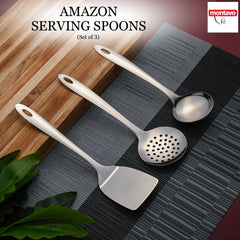 Montavo Amazon serving spoons 3-piece set displayed on gray placemat with wooden cutting board in modern kitchen setting