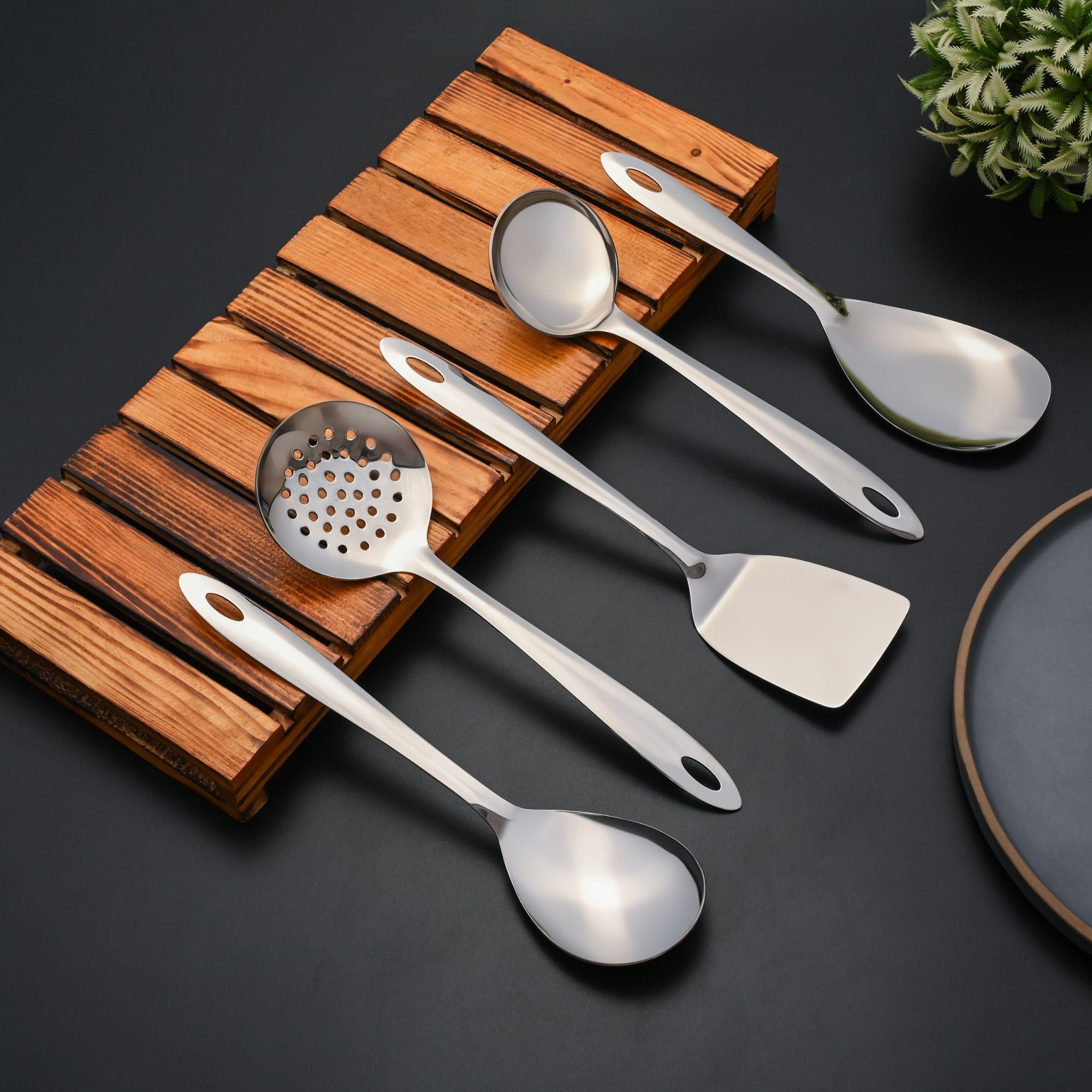 Montavo stainless steel serving spoons collection arranged on wooden holder in kitchen setting