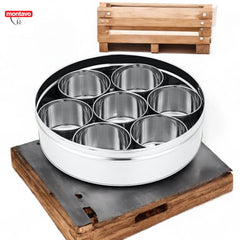 Montavo by fns stainless steel masala box with lid removed showing 7 polished stainless steel inner containers, placed on a rustic wooden stand on white background
