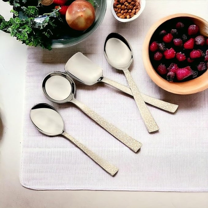Pacific serving set with 4 pieces featuring textured handles displayed on white tablecloth with fresh berries and breakfast items