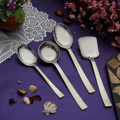 Pacific serving set arranged on purple fabric with decorative flowers, shells, and lace doily for elegant table display
