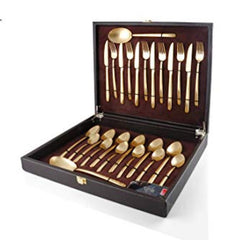 Elegant gold flatware set arranged in a black presentation box with velvet lining and clasp.