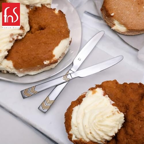 Pair of stainless steel dinner knives with gold geometric chevron pattern handles displayed parallel on white background for modern flatware collection.