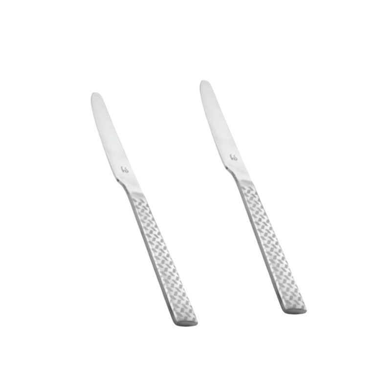 Pair of polished stainless steel Rhombo dinner knives with eye-catching geometric diamond pattern handles arranged diagonally on clean white background.
