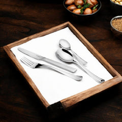 Elegant four-piece cutlery set arranged on a wooden tray beside bowls of nuts and food.