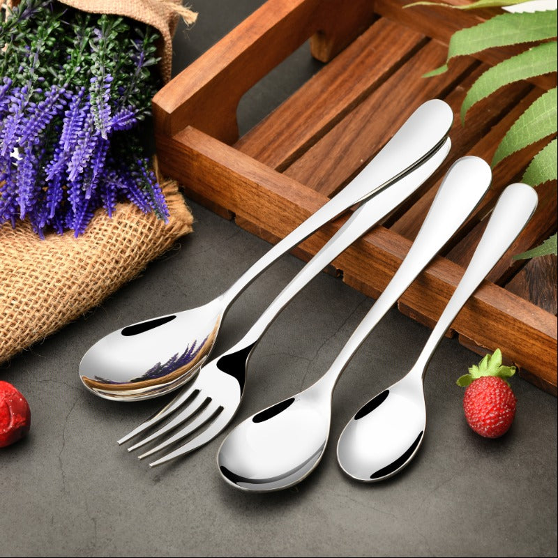 Sleek stainless steel cutlery set placed beside lavender flowers, wood tray, and fresh strawberries.