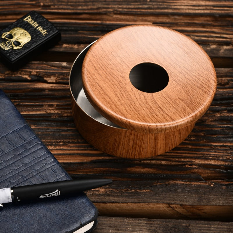 Wood grain finish ashtray with stainless steel interior and center opening on rustic wooden desk with notebook, pen, and Death Note book